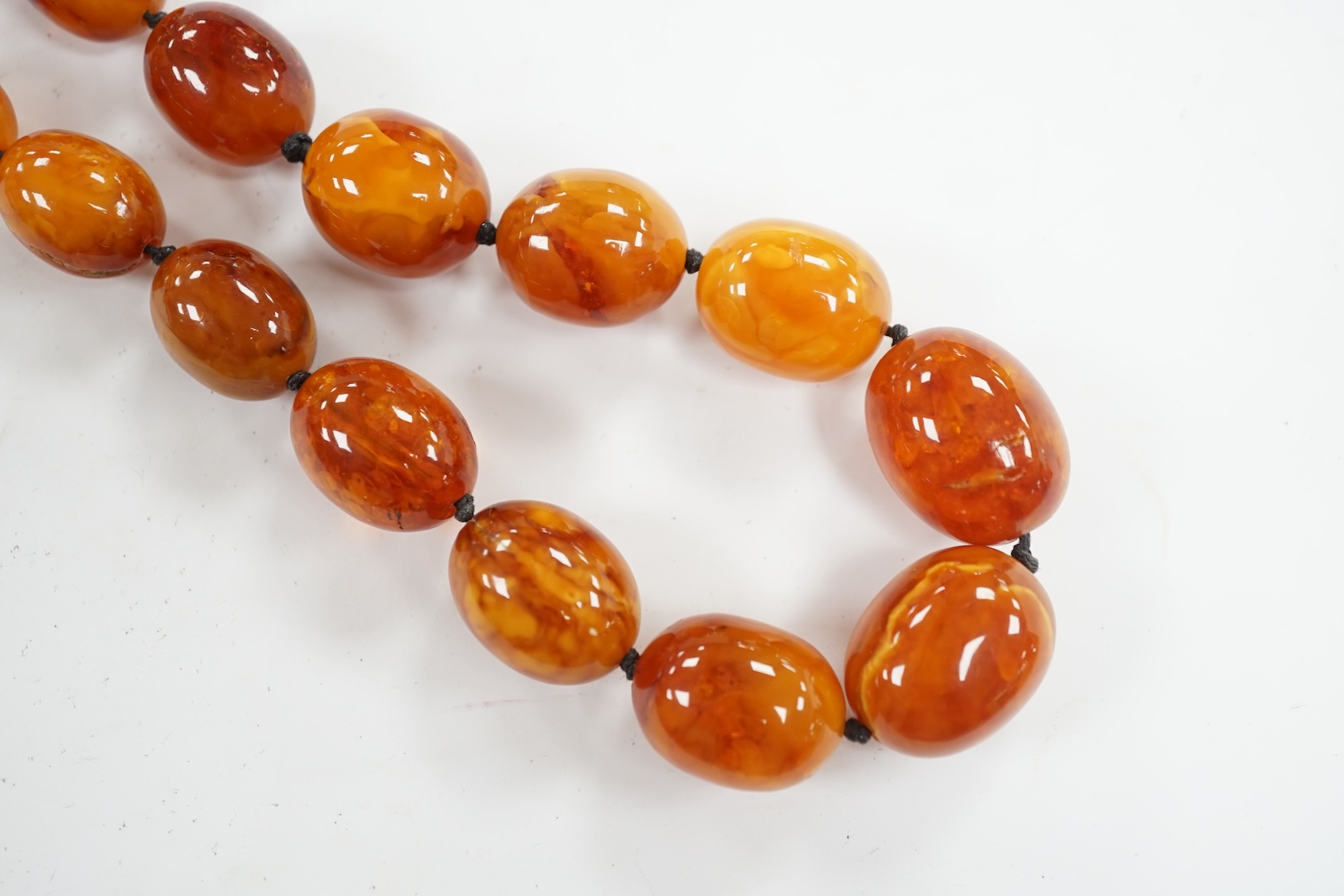 A single strand graduated oval amber bead necklace, 76cm, gross weight 107 grams. Condition - poor